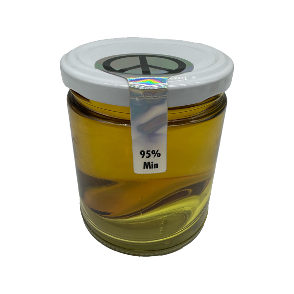 Close-up view of a premium THC distillate jar showing its super-clear color and high-quality content.