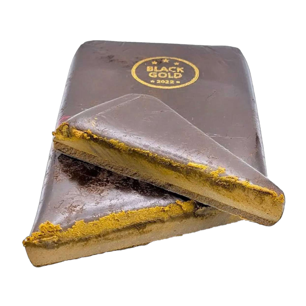 A close-up of Black Gold Hash, sliced open to reveal its golden-brown, resin-rich interior.