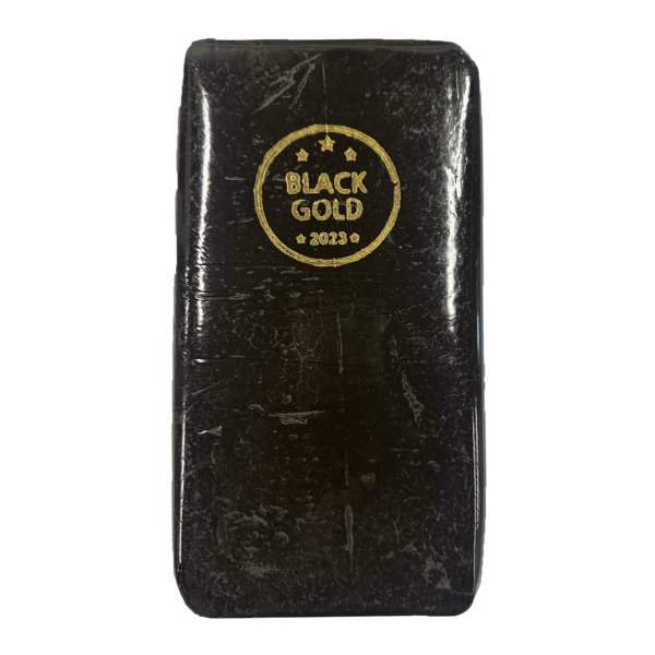 A slab of Black Gold Hash with a sleek, dark surface and a gold stamp marking its premium quality